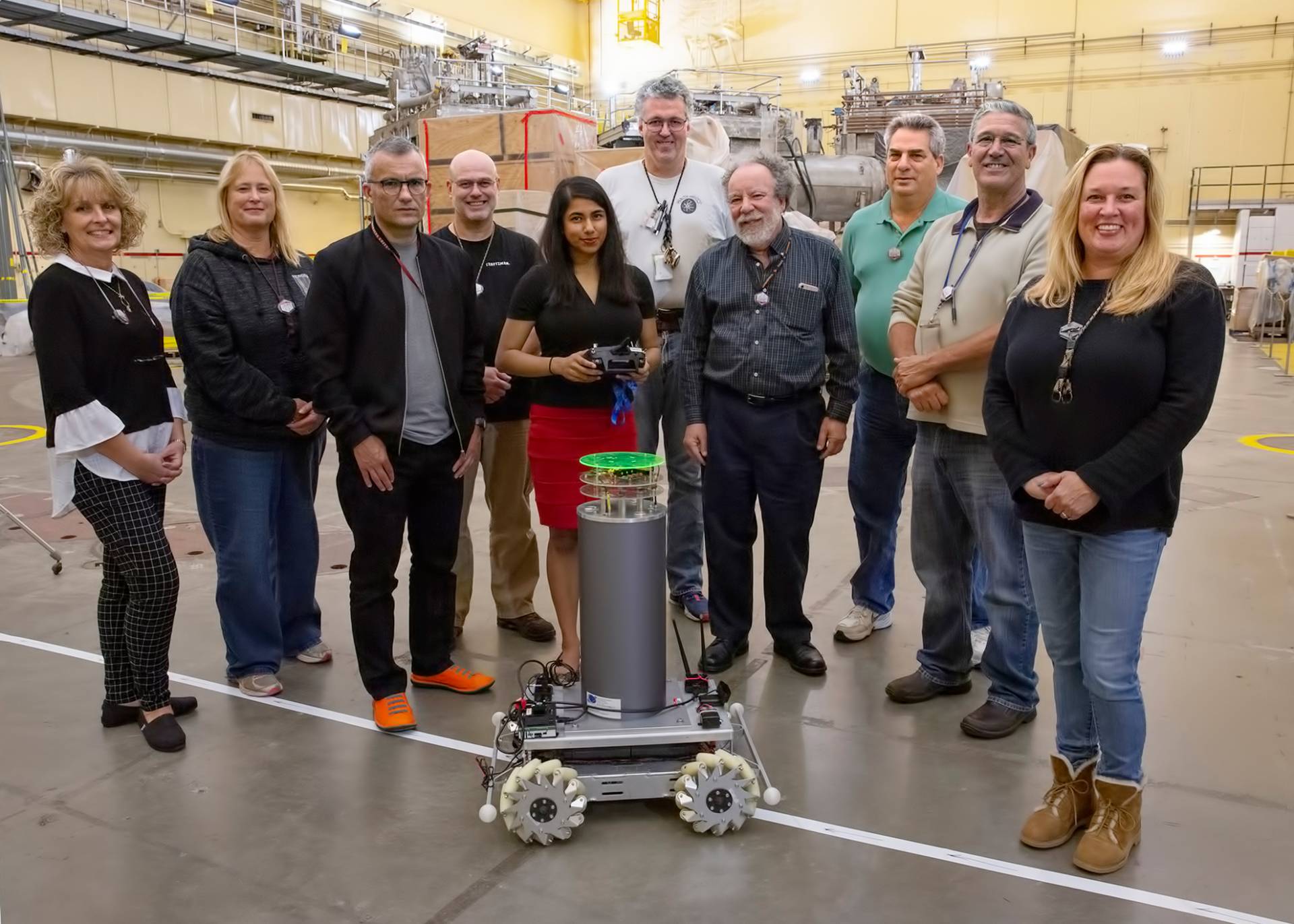 A group of scientists surround the machine