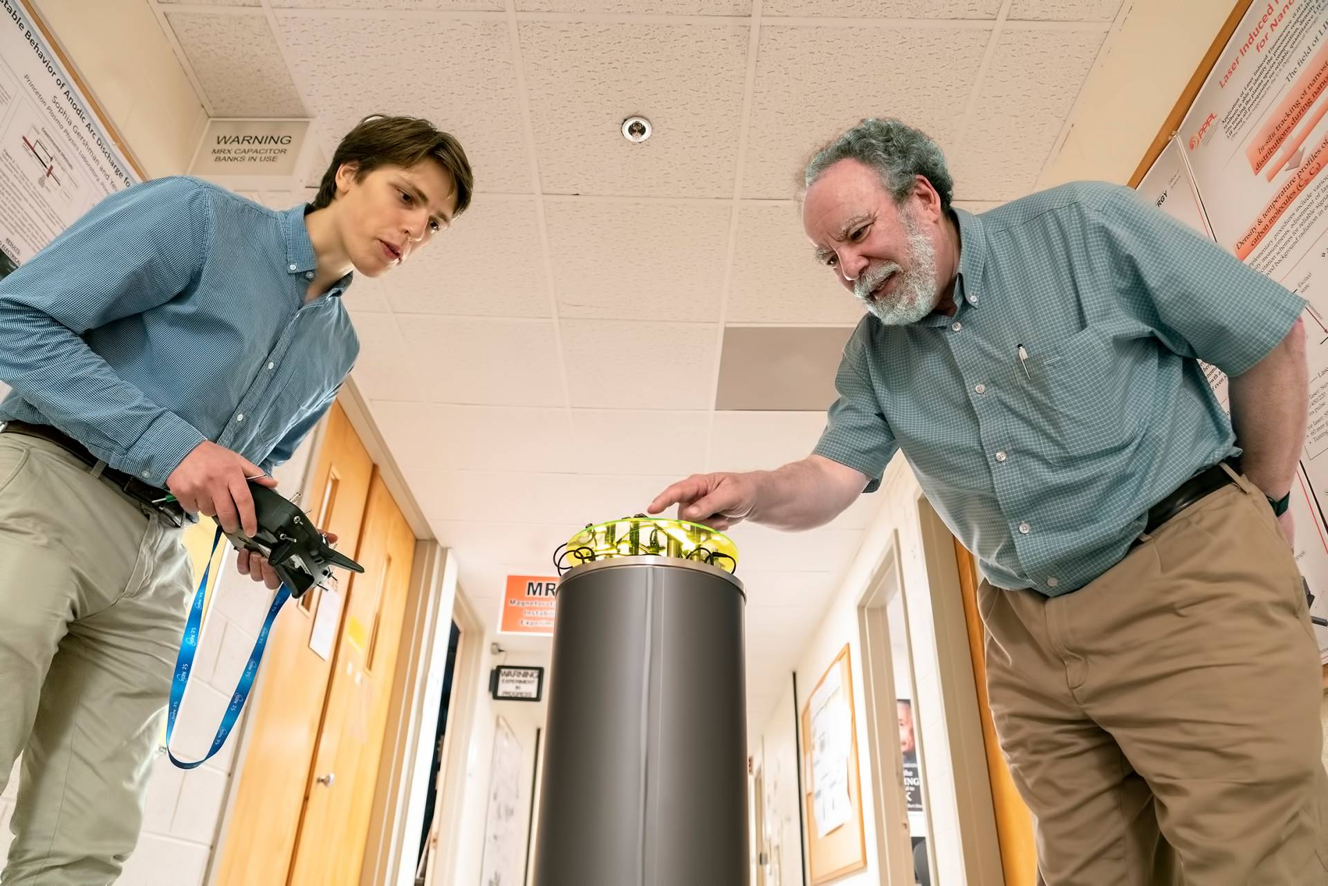 2 scientists examine a machine