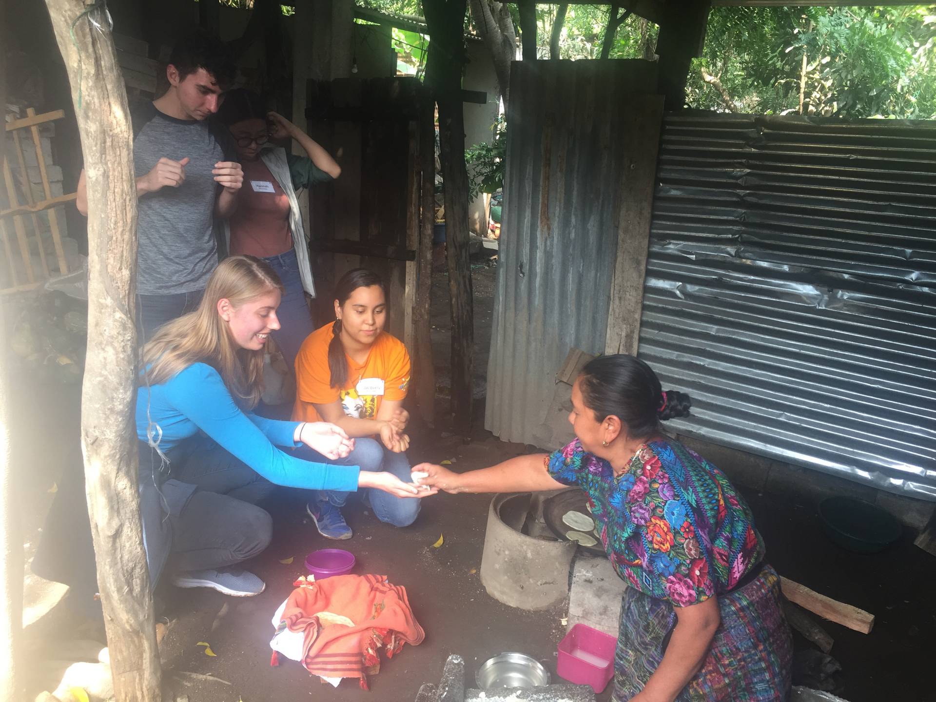 A woman gives a student a freshly made tortilla