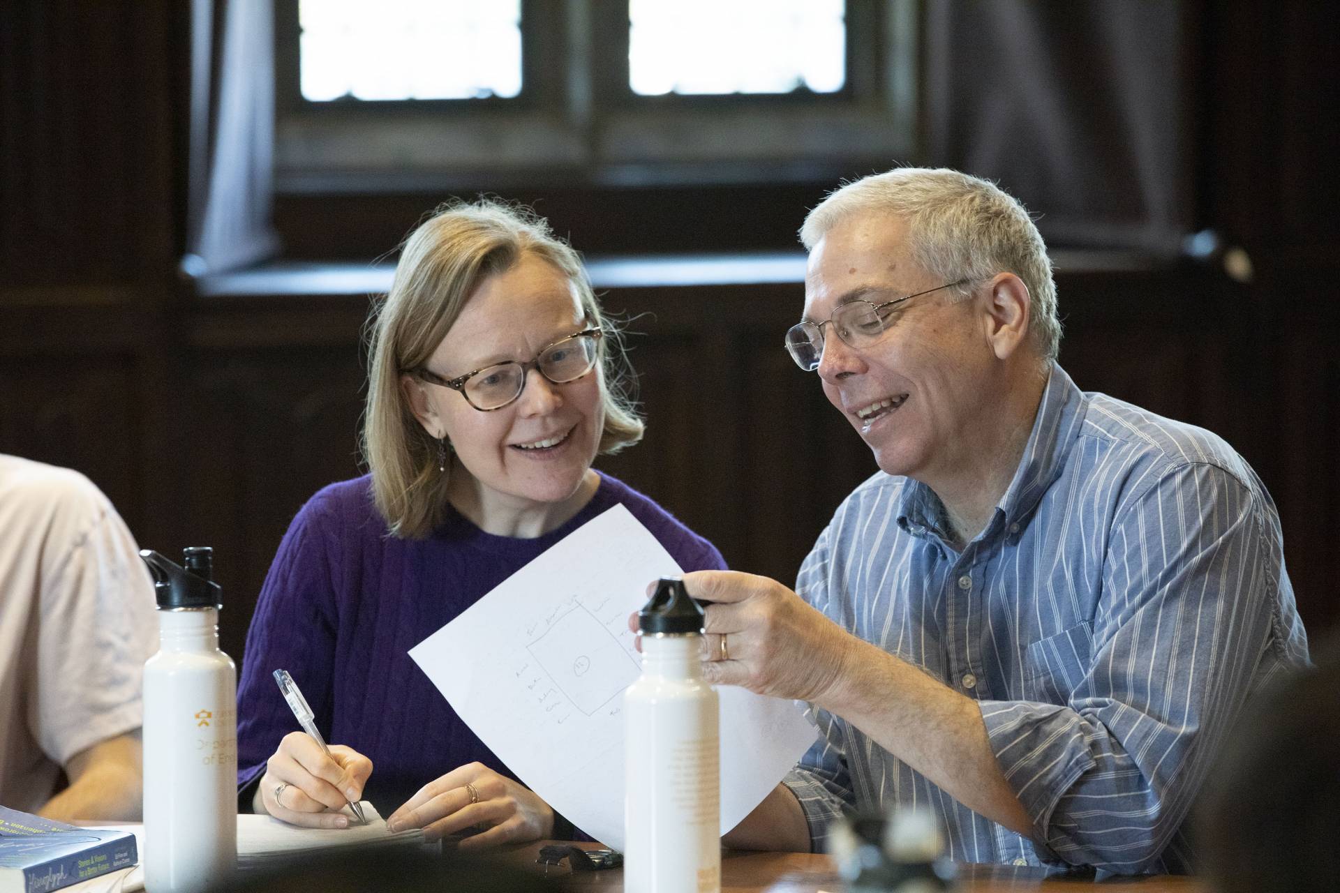 Kate Thorpe and William Gleason point to something on a paper