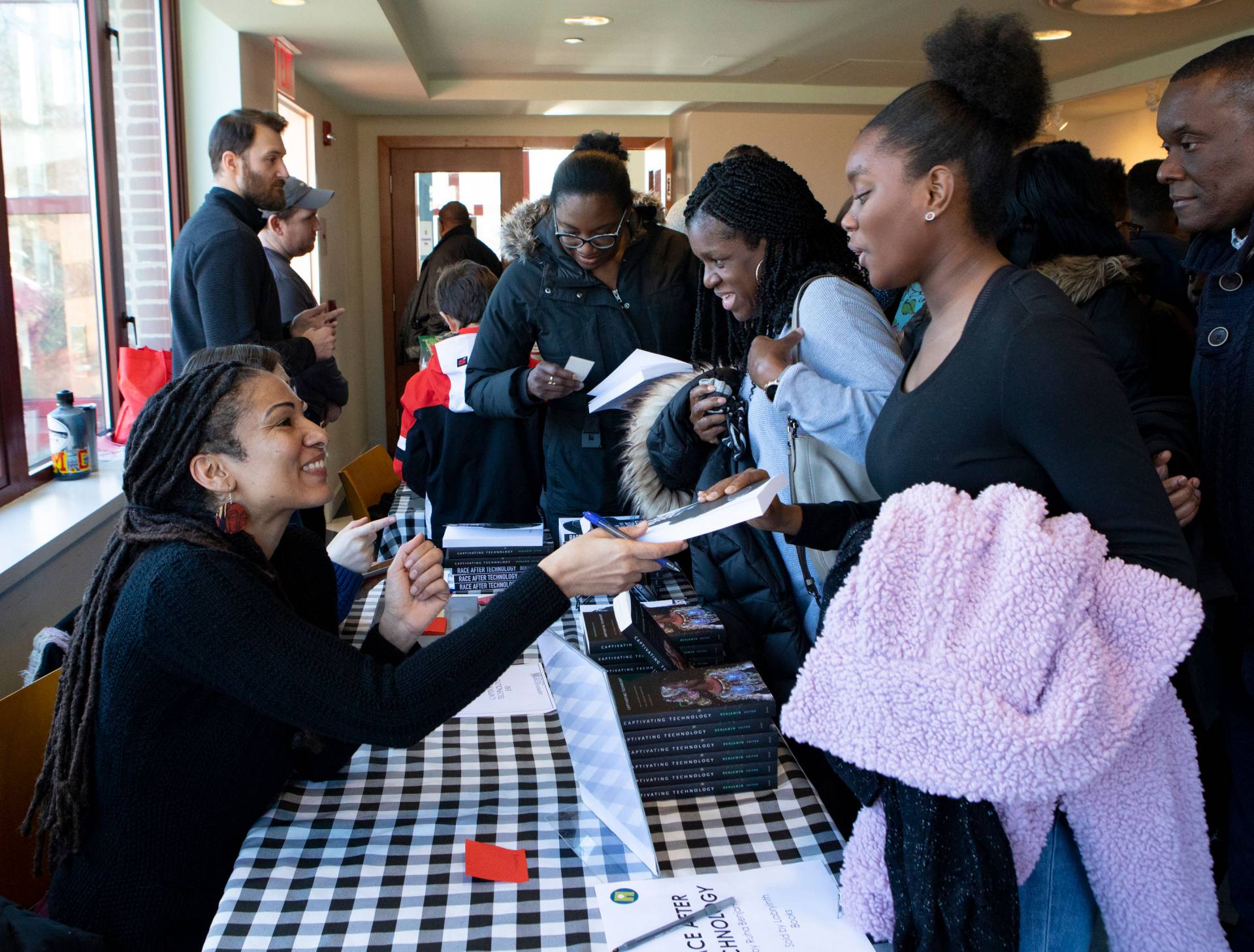 Ruha Benjamin signing books for community members