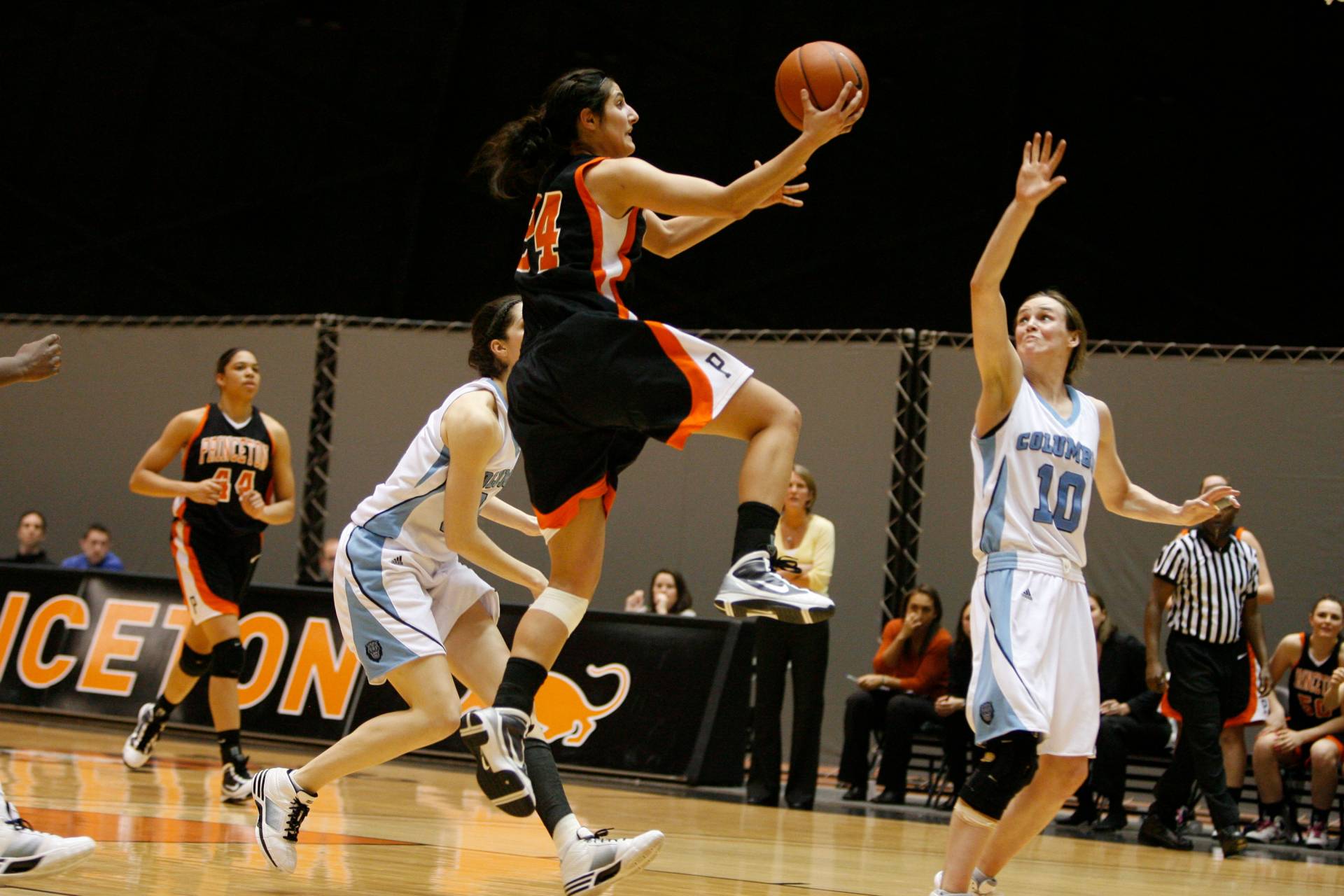 a basketball player jumps to make a basket