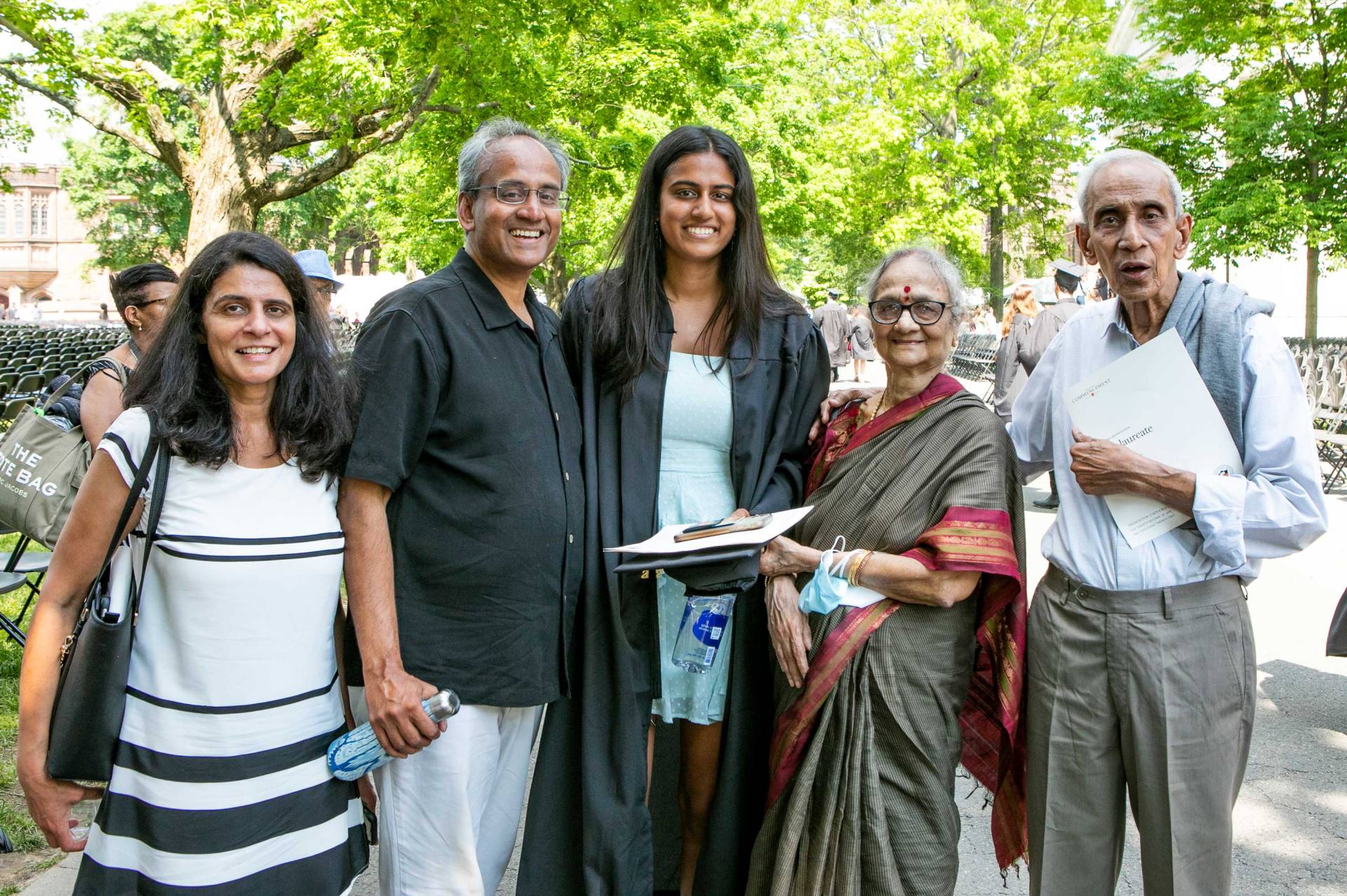 a happy family pose with their graduating daughter