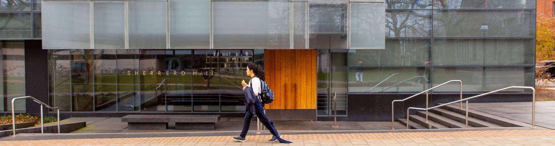 Female student walks by Sherrerd Hall