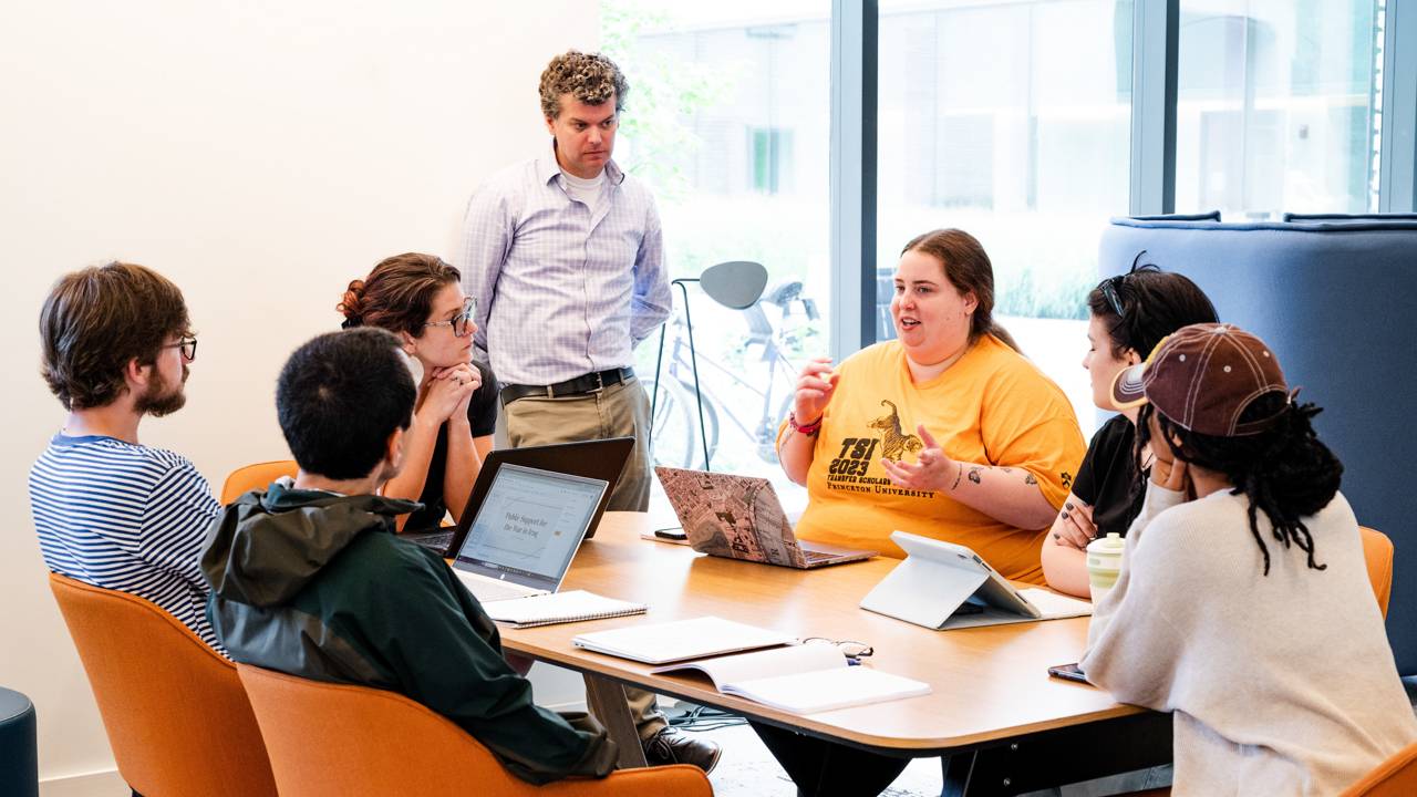 Students having a discussion around a table.