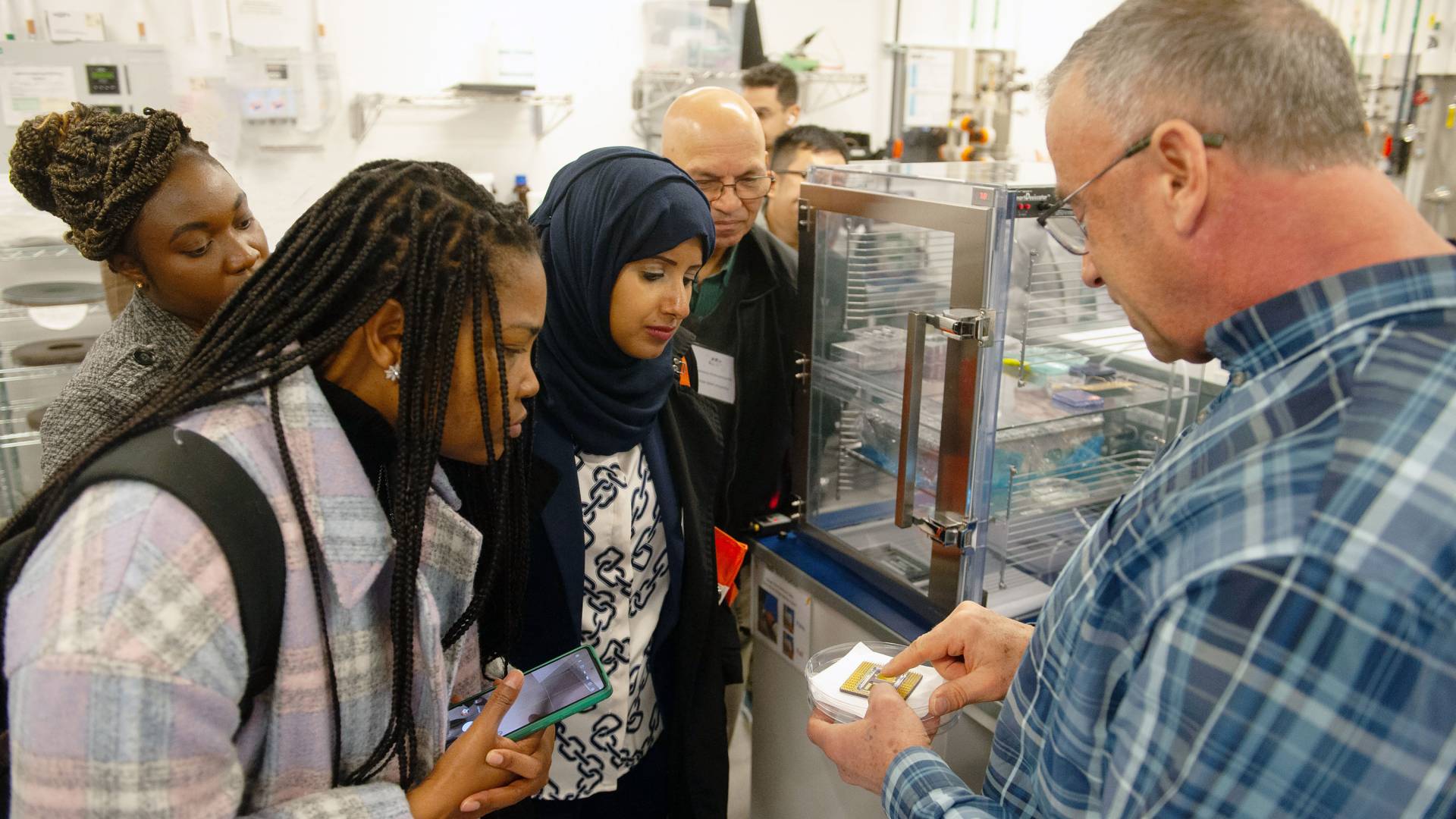 Visitors crowd around a computer chip in the hands of Bert Harrop