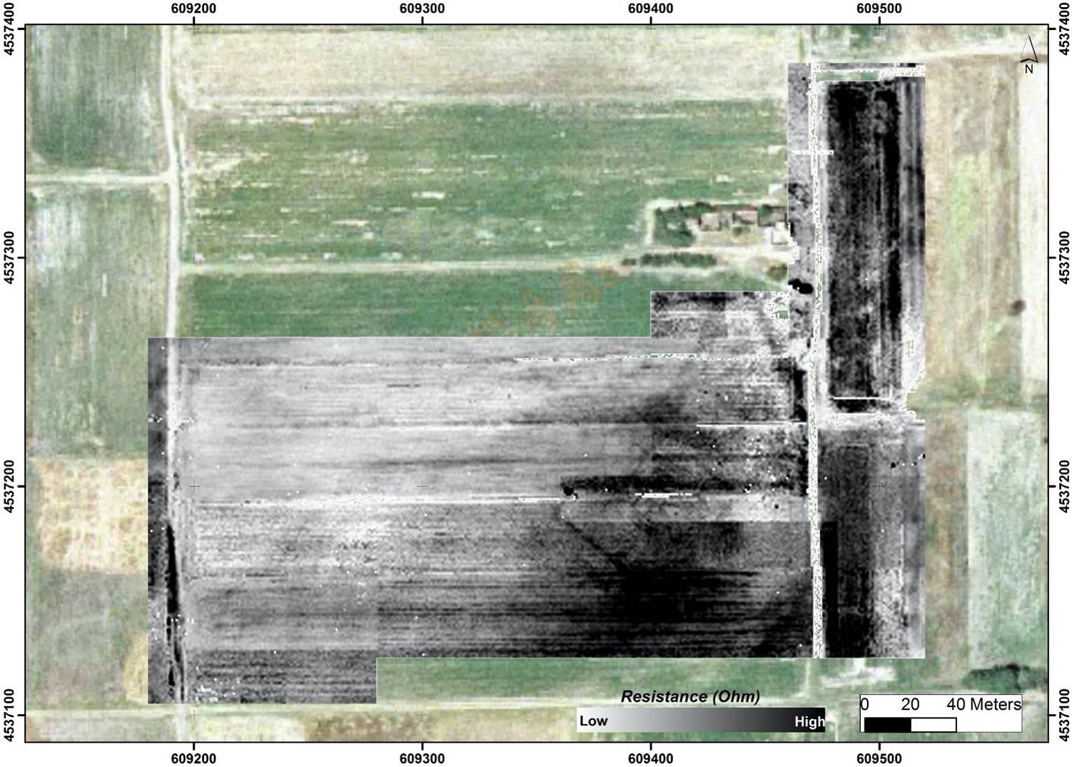 A view of a field from above, patches of green and black signifying what's underground.