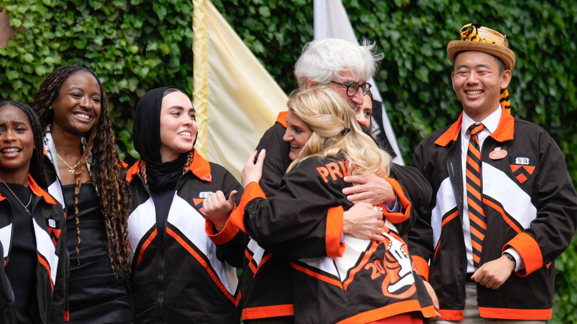 A class officer hugs Waterston after presenting him with his class jacket