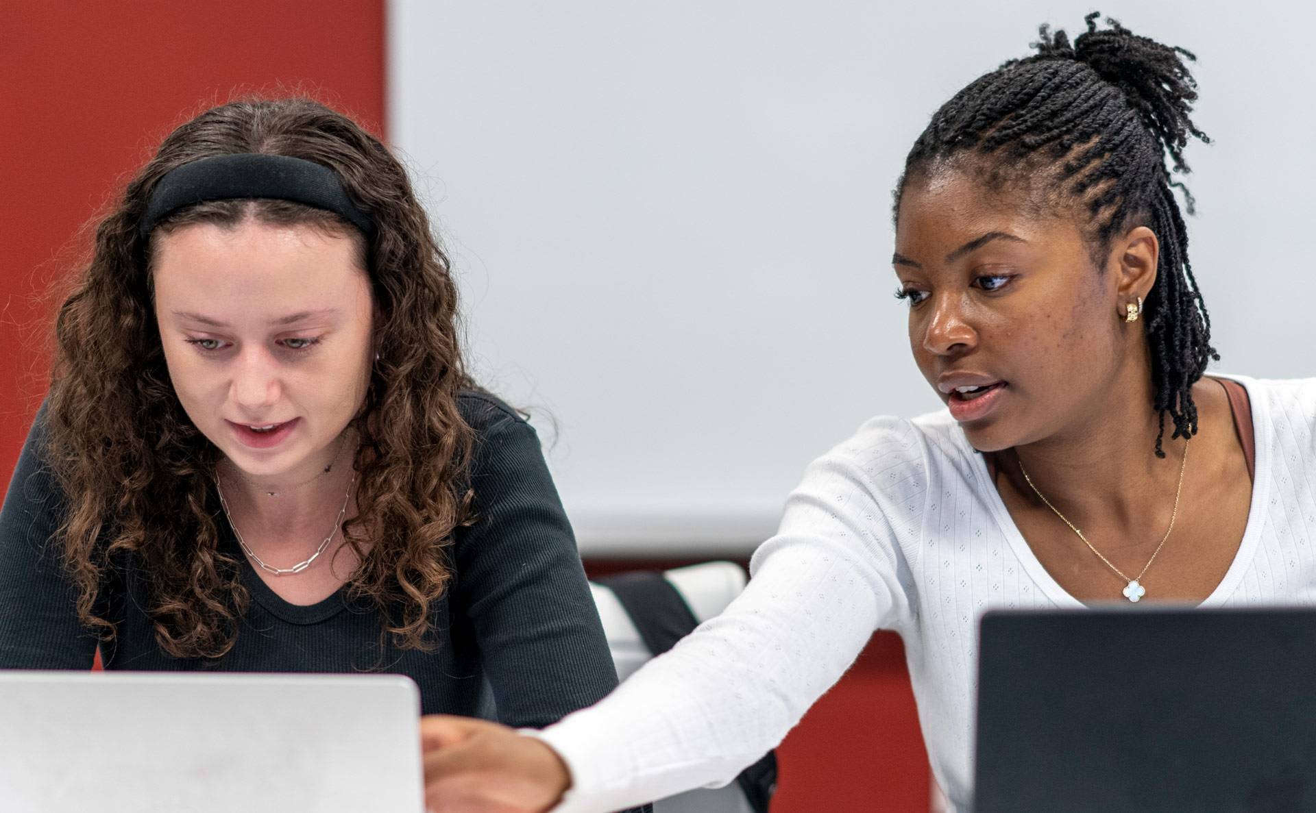 Two students in class sharing a laptop