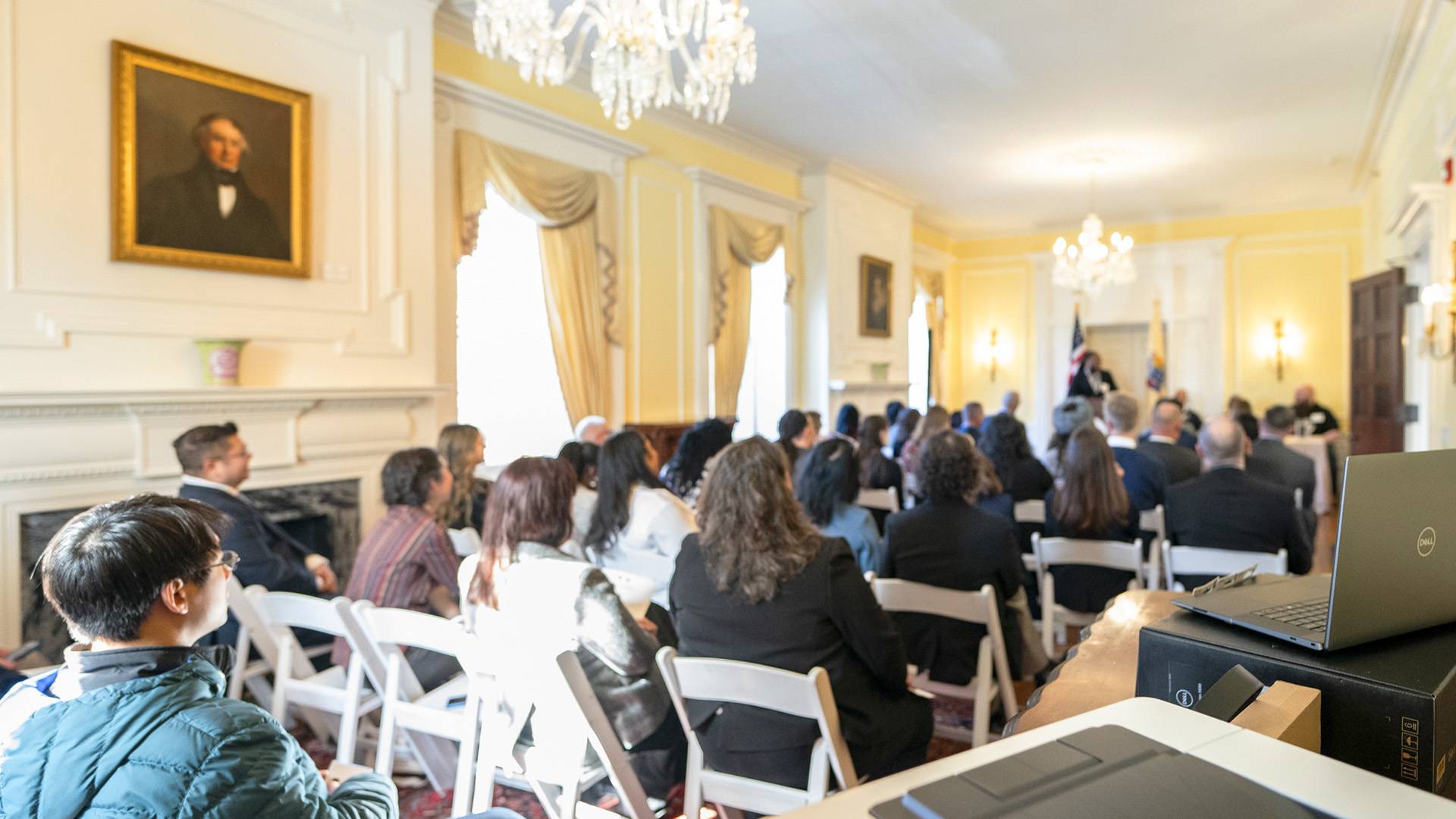Full room of people listening to speakers on the PTI program
