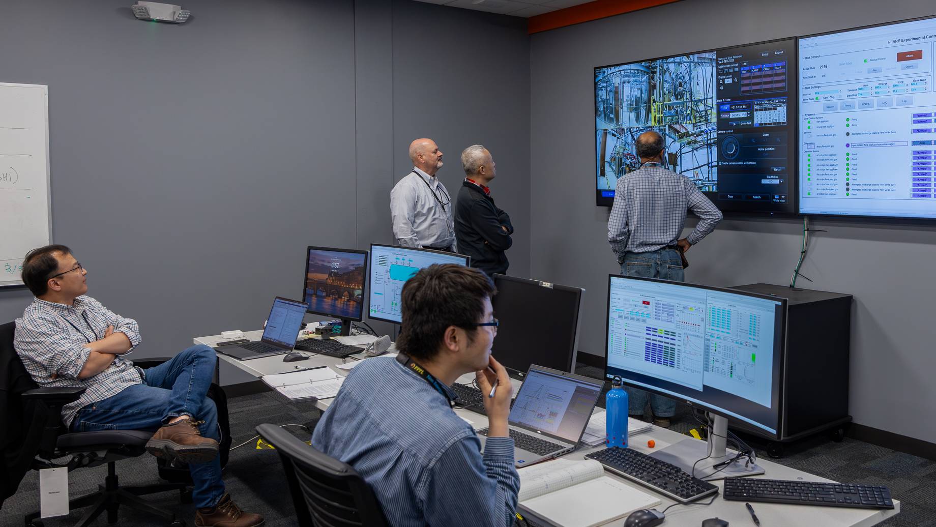 Scientists at FLARE look at monitors in the facility's control room. 