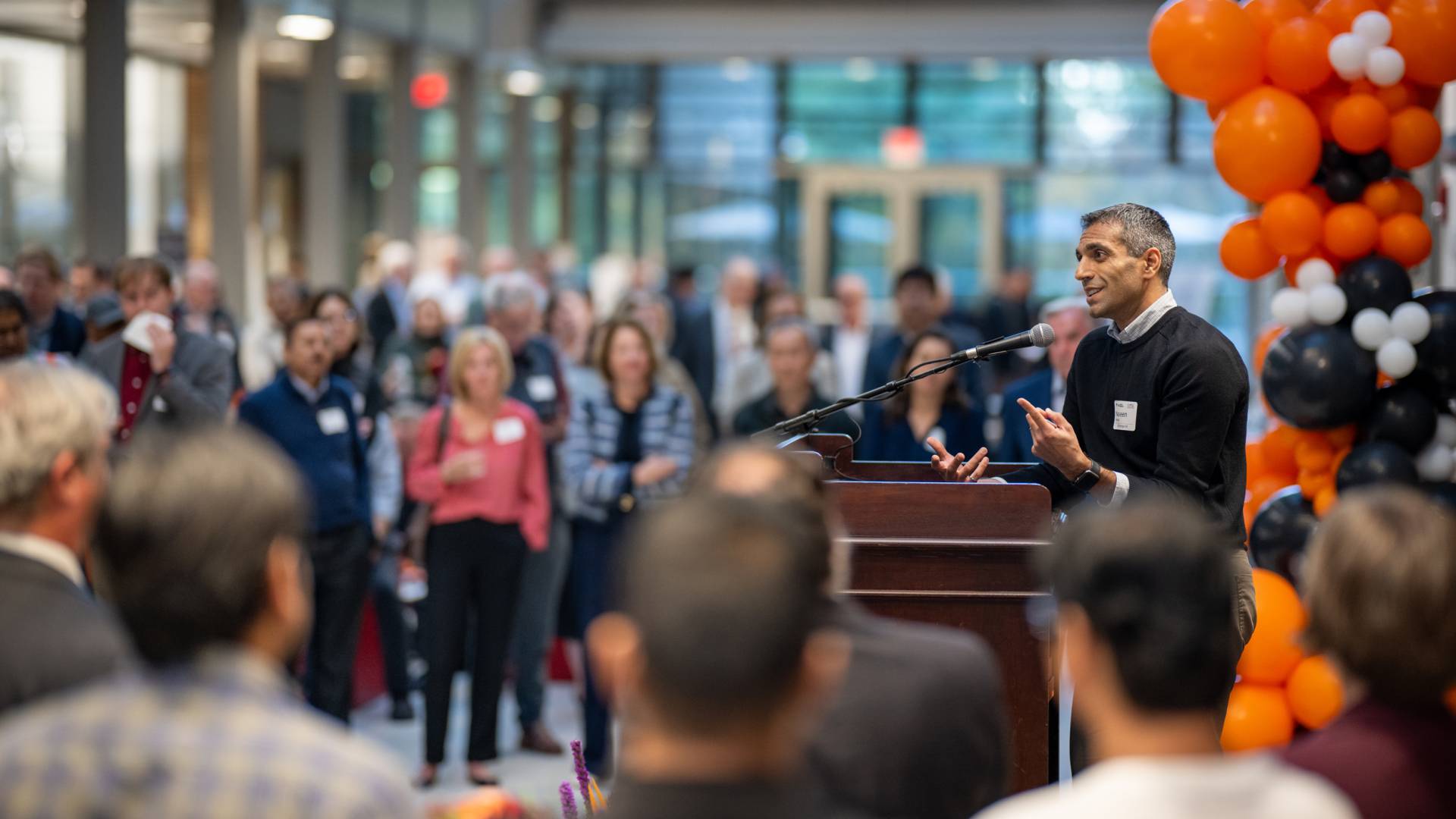 Professor Naveen Verma speaks from the podium to the crowd.