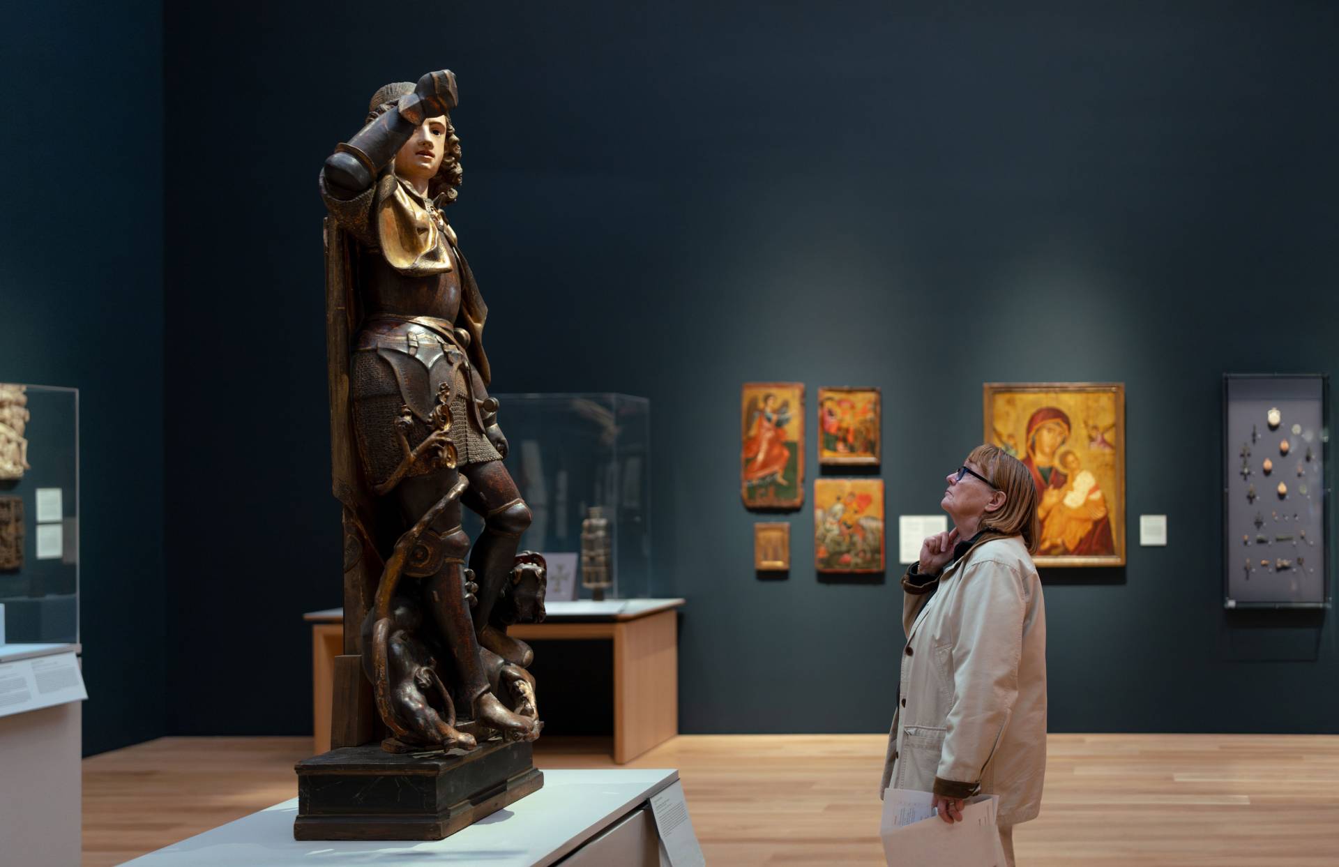 A visitor to the museum observes a statue in one of the galleries.