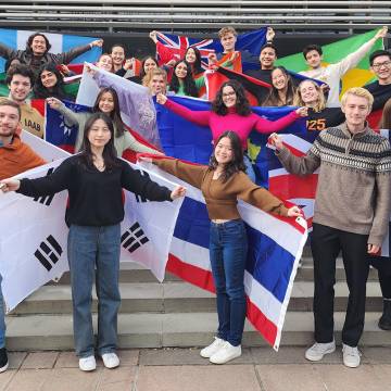 Students hold flags from different countries they are from