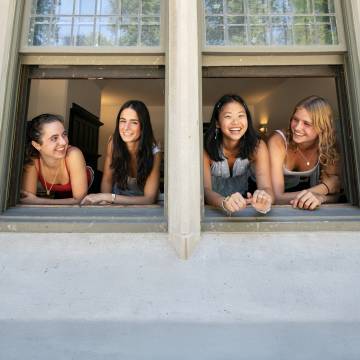 students smiling faces in window frame