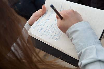 Artist at Work student writing in notebook