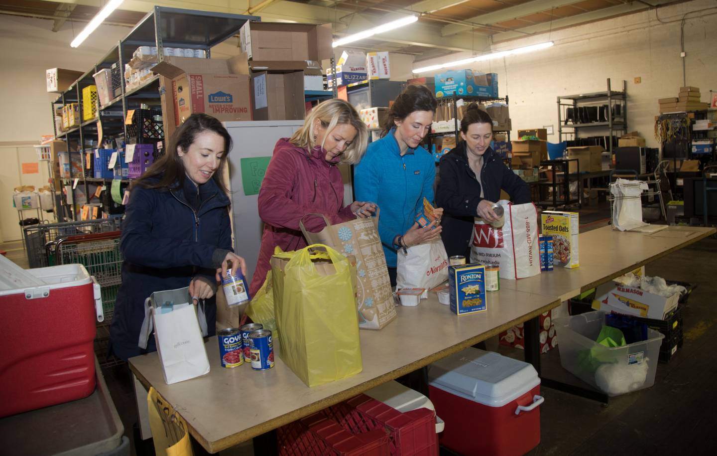 Kaitlin Lutz, Debby Foster, Jaclyn Sweet and Leslie Rowley pack bags of food