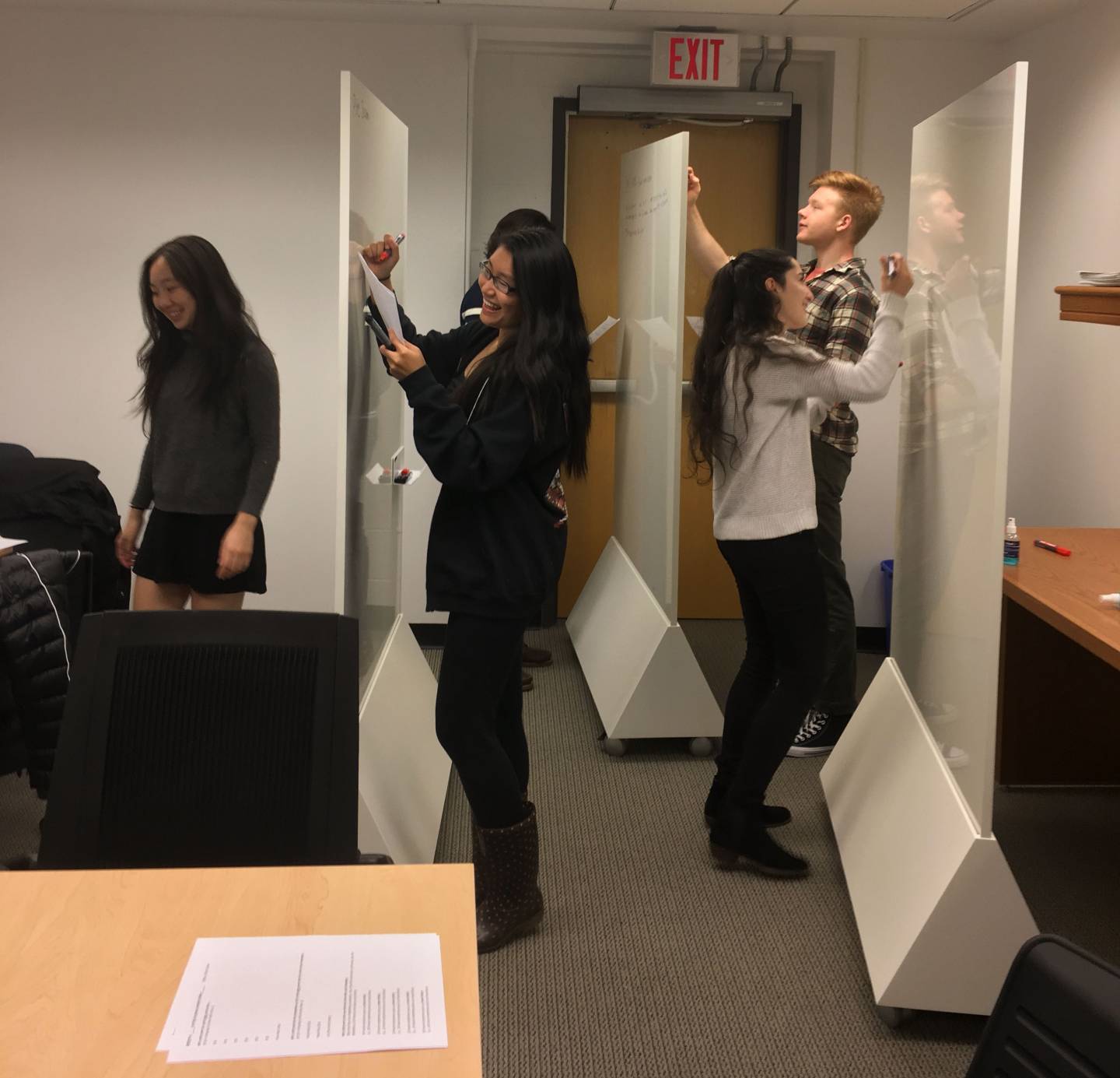 Students writing on movable whiteboards