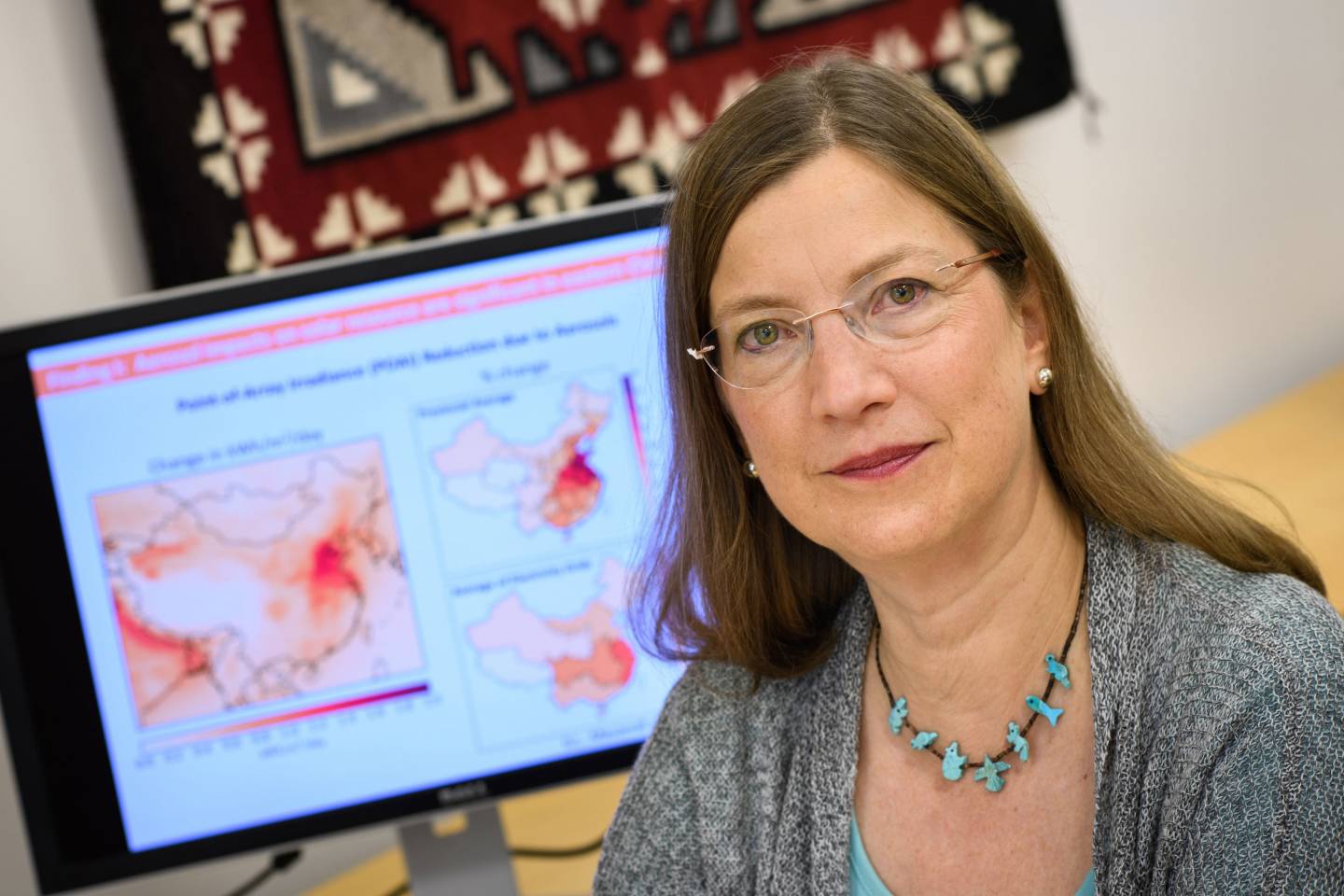 Denise Mauzerall in front of maps on a computer screen