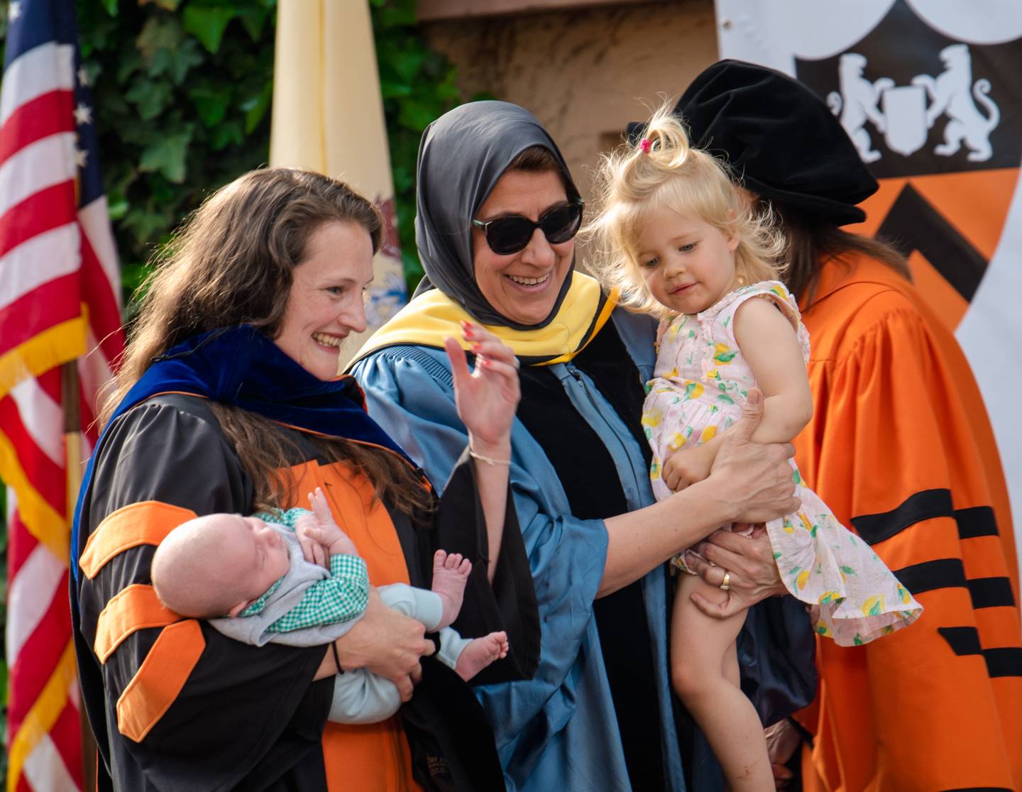 Mother holds infant while Dean Jamal holds mother's toddler daughter