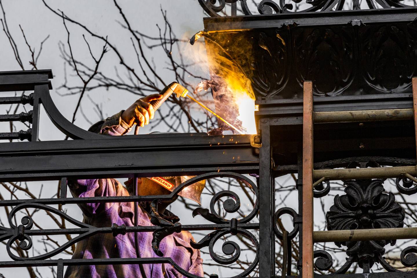 A welder secures part of the top of the gate