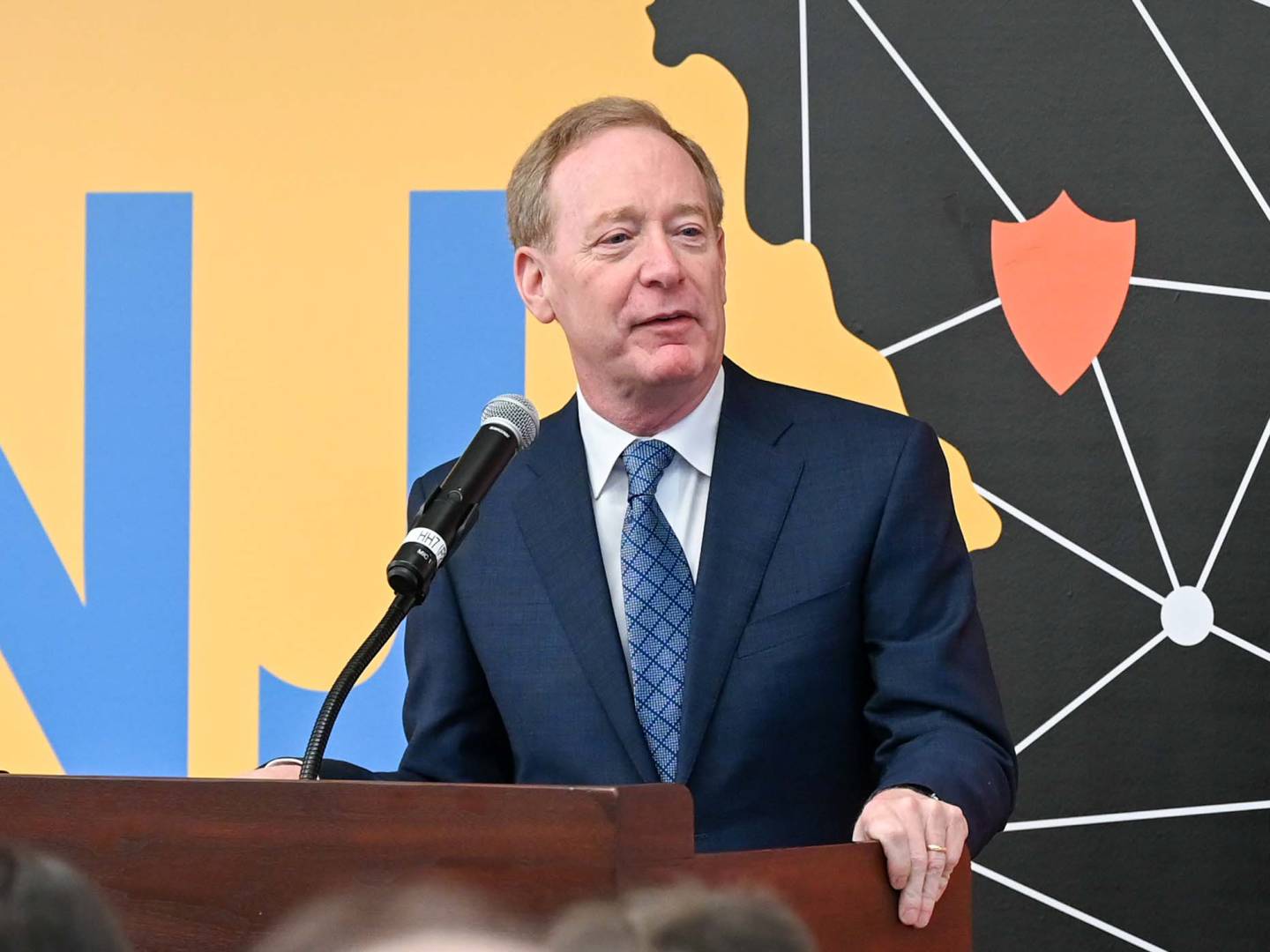 Microsoft's Brad Smith speaks in front of the NJ AI logo.